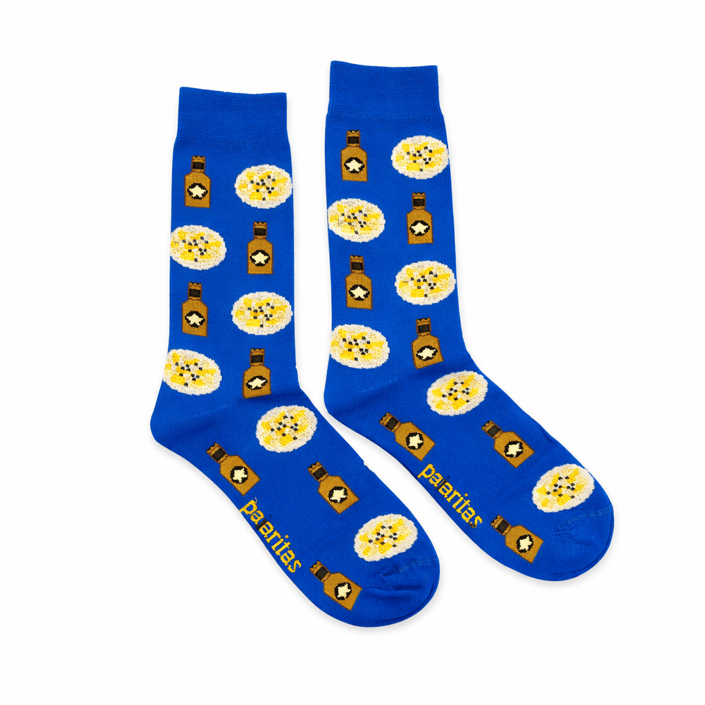 Calcetines Pataticas y Olivas Tapa Azul, calcetines originales murcianos con diseño de patatas aliñadas y botellines de aceitunas. Calcetines azules divertidos fabricados en España, ideales para amantes del aperitivo, la gastronomía murciana y los accesorios originales. Calcetines de algodón cómodos y transpirables, talla única 40-46, perfectos para regalo o para llevar un estilo diferente. English Blue Pataticas and Olivas socks inspired by Murcia tapas culture. Original food design socks featuring seasoned potatoes and olive bottles pattern. Comfortable cotton socks made in Spain, breathable and durable. Fun novelty socks perfect for food lovers, Spanish gastronomy fans and unique style accessories. One size 40-46 ideal gift socks. Italiano Calzini Pataticas e Olive Tapa Blu ispirati alla tradizione delle tapas murciane. Calzini originali con disegno di patate condite e bottigliette di olive. Calzini divertenti in cotone prodotti in Spagna, comodi e traspiranti. Accessorio perfetto per amanti della gastronomia spagnola, tapas e moda originale. Taglia unica 40-46 ideali anche come regalo. Français Chaussettes Pataticas et Olives Tapa Bleu inspirées de l’apéritif murcien. Chaussettes originales avec motif de pommes de terre assaisonnées et bouteilles d’olives. Chaussettes amusantes en coton fabriquées en Espagne, confortables et respirantes. Idéales pour les amateurs de tapas, gastronomie espagnole et accessoires originaux. Taille unique 40-46 parfaites pour cadeau.
