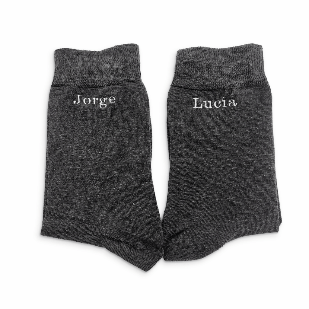 Calcetines gris oscuro para novio bordados personalizados con nombres Jorge y Lucía, calcetines elegantes de boda hechos en España, detalle exclusivo para novio con bordado blanco visible, calcetines personalizados para boda en Murcia, regalo original para novio y padrino, calcetines de algodón gris oscuro con bordado artesanal, complemento elegante para traje de boda, calcetines personalizados con iniciales o fecha especial, producto hecho a mano en taller de Calle Jabonerías 6 Murcia, calcetines cómodos y transpirables para eventos, idea de regalo personalizada para bodas, calcetines originales para hombre, accesorio de moda masculino con bordado personalizado, detalle único para ceremonia, calcetines para invitados de boda personalizados, diseño elegante y moderno, calcetines de alta calidad fabricados en España, bordado profesional duradero y preciso, calcetines exclusivos para ocasiones especiales 🇬🇧 English (ALT) Dark grey groom socks with custom embroidery featuring names Jorge and Lucia, personalized wedding socks made in Spain, elegant men’s dress socks with white embroidered names, custom groom accessories for weddings, unique personalized gift for groom or best man, high quality cotton dark grey socks with artisan embroidery, handmade socks crafted in Murcia Spain, stylish wedding socks for men, custom socks with initials or wedding date, breathable and comfortable formal socks, modern and elegant men’s accessory for special occasions, personalized socks for wedding guests, premium fabric socks with durable embroidery, bespoke wedding fashion accessory, custom embroidered socks for events, luxury men’s socks for suits, elegant and minimal design, original gift idea for weddings and celebrations, high-end personalized socks crafted with care 🇫🇷 Français (ALT) Chaussettes gris foncé pour marié avec broderie personnalisée noms Jorge et Lucia, chaussettes élégantes pour mariage fabriquées en Espagne, chaussettes homme personnalisées avec broderie blanche, accessoire de mariage unique pour marié, idée cadeau originale pour mariage ou témoin, chaussettes en coton de haute qualité avec broderie artisanale, produit fait main à Murcia Espagne, chaussettes personnalisées avec initiales ou date spéciale, accessoire élégant pour costume de mariage, chaussettes confortables et respirantes pour événements, design moderne et raffiné, chaussettes sur mesure pour occasions spéciales, cadeau personnalisé pour invités de mariage, chaussettes haut de gamme avec finition soignée, broderie durable et précise, accessoire mode homme personnalisé, produit artisanal espagnol de qualité supérieure 🇮🇹 Italiano (ALT) Calzini grigio scuro da sposo con ricamo personalizzato nomi Jorge e Lucia, calzini eleganti per matrimonio fatti in Spagna, calzini uomo personalizzati con ricamo bianco, accessorio unico per sposo, idea regalo originale per matrimonio o testimone, calzini in cotone di alta qualità con ricamo artigianale, prodotto fatto a mano a Murcia Spagna, calzini personalizzati con iniziali o data speciale, accessorio elegante per abito da cerimonia, calzini comodi e traspiranti per eventi, design moderno e raffinato, calzini su misura per occasioni speciali, regalo personalizzato per invitati di matrimonio, calzini premium con ricamo resistente e preciso, accessorio moda uomo personalizzato, prodotto artigianale spagnolo di alta qualità