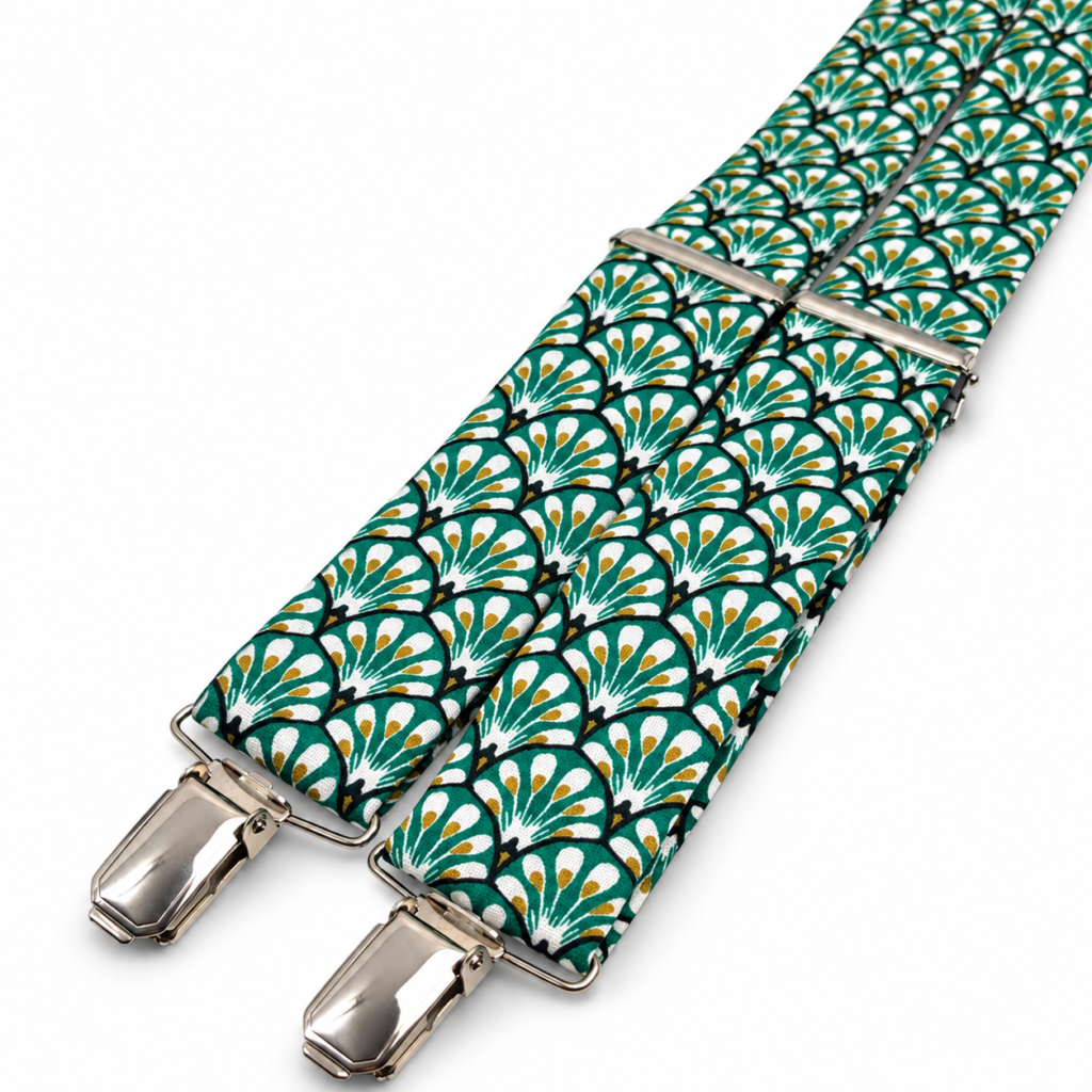 Tirantes Art Deco Verde para hombre fabricados artesanalmente en el taller de Pajaritas con Jota en Murcia, España. El diseño presenta un elegante estampado geométrico de inspiración Art Déco con motivos repetidos en forma de abanico y una combinación de colores verde esmeralda, blanco, negro y mostaza. Los tirantes incorporan reguladores y pinzas metálicas en acabado plateado que permiten ajustar su longitud y sujetarlos cómodamente al pantalón. Son unos tirantes originales para bodas, novios, invitados, padrinos, comuniones, bautizos, graduaciones, celebraciones y eventos especiales. Combinan especialmente bien con trajes azul marino, beige, arena, gris, verde oscuro y negro, así como con camisas blancas, crema, marfil, azul celeste o verde claro. Complemento masculino artesanal hecho a mano en España y perfecto también como regalo original. ALT text in English Green Art Deco suspenders for men, handmade in the Pajaritas con Jota workshop in Murcia, Spain. The fabric features an elegant geometric Art Deco inspired pattern with repeated fan-shaped motifs in emerald green, white, black and mustard tones. The suspenders include polished silver-tone metal adjusters and strong clips, allowing the length to be adjusted easily and securely attached to trousers. These original patterned suspenders are ideal for weddings, grooms, wedding guests, best men, baptisms, communions, graduations, celebrations and special events. They pair beautifully with navy blue, beige, sand, grey, dark green or black suits and with white, cream, ivory, light blue or pale green shirts. A distinctive handmade men's accessory made in Spain and an excellent original gift for someone who enjoys elegant and unusual fashion accessories. Texte ALT en français Bretelles Art Déco Vertes pour homme fabriquées artisanalement dans l'atelier Pajaritas con Jota à Murcie, en Espagne. Le tissu présente un élégant motif géométrique inspiré du style Art Déco, composé de formes répétées en éventail dans des tons vert émeraude, blanc, noir et moutarde. Les bretelles disposent de réglages et de pinces métalliques finition argentée permettant d'ajuster facilement la longueur et de les fixer au pantalon. Ces bretelles originales sont idéales pour les mariages, mariés, invités, témoins, communions, baptêmes, remises de diplômes, fêtes et événements spéciaux. Elles se marient parfaitement avec des costumes bleu marine, beige, sable, gris, vert foncé ou noir et avec des chemises blanches, crème, ivoire, bleu ciel ou vert clair. Un accessoire masculin élégant fait main en Espagne et parfait comme cadeau original. Testo ALT in italiano Bretelle Art Déco Verdi da uomo realizzate artigianalmente nel laboratorio Pajaritas con Jota a Murcia, in Spagna. Il tessuto presenta un elegante motivo geometrico ispirato allo stile Art Déco, con elementi ripetuti a forma di ventaglio nei colori verde smeraldo, bianco, nero e senape. Le bretelle sono dotate di regolatori e clip metalliche con finitura argentata che permettono di regolare facilmente la lunghezza e fissarle comodamente ai pantaloni. Sono perfette per matrimoni, sposi, invitati, testimoni, comunioni, battesimi, lauree, feste ed eventi speciali. Si abbinano molto bene a completi blu navy, beige, sabbia, grigi, verde scuro o neri e a camicie bianche, crema, avorio, azzurro chiaro o verde tenue. Un accessorio maschile originale fatto a mano in Spagna e ideale anche come regalo elegante e particolare.