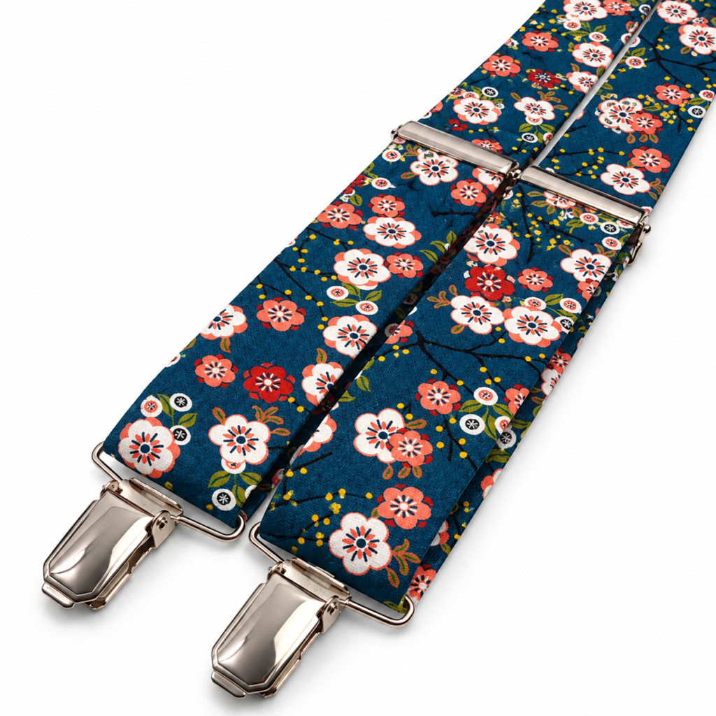 Tirantes Jardín Japonés para hombre fabricados artesanalmente a mano en el taller de Pajaritas con Jota en Murcia, España. El diseño presenta un elegante fondo azul petróleo decorado con un estampado floral de inspiración japonesa compuesto por flores blancas, coral, rosas y rojizas, pequeñas hojas verdes, ramas oscuras y delicados detalles amarillos. Los tirantes incorporan reguladores metálicos y pinzas plateadas que permiten ajustar fácilmente la longitud y sujetarlos directamente al pantalón. Son unos tirantes originales para bodas, novios, invitados, padrinos, comuniones, bautizos, graduaciones, fiestas y eventos especiales. Combinan especialmente bien con trajes azul marino, azul, gris, beige, arena, gris antracita o negro y con camisas blancas, azul celeste, crema, marfil o rosa claro. Complemento masculino floral hecho a mano en España y perfecto también como regalo original. ALT text in English Japanese Garden suspenders for men, handmade in the Pajaritas con Jota workshop in Murcia, Spain. The fabric features an elegant petrol blue background decorated with a Japanese-inspired floral print composed of white, coral, pink and reddish flowers, small green leaves, dark branches and delicate yellow accents. The suspenders include polished silver-tone metal adjusters and strong metal clips, allowing the length to be adjusted easily and attached securely to trousers. These original floral suspenders are ideal for weddings, grooms, wedding guests, best men, baptisms, communions, graduations, parties and special events. They pair beautifully with navy blue, blue, grey, beige, sand, charcoal or black suits and with white, light blue, cream, ivory or pale pink shirts. A distinctive handmade men's accessory made in Spain and also an excellent original gift idea. Texte ALT en français Bretelles Jardin Japonais pour homme fabriquées artisanalement dans l'atelier Pajaritas con Jota à Murcie, en Espagne. Le tissu présente un élégant fond bleu pétrole décoré d'un motif floral d'inspiration japonaise composé de fleurs blanches, corail, roses et rouges, de petites feuilles vertes, de branches foncées et de délicates touches jaunes. Les bretelles disposent de réglages métalliques et de pinces finition argentée permettant d'ajuster facilement leur longueur et de les fixer directement au pantalon. Ces bretelles fleuries originales sont idéales pour les mariages, mariés, invités, témoins, communions, baptêmes, remises de diplômes, fêtes et événements spéciaux. Elles se marient parfaitement avec des costumes bleu marine, bleus, gris, beige, sable, anthracite ou noirs et avec des chemises blanches, bleu ciel, crème, ivoire ou rose clair. Un accessoire masculin élégant fait main en Espagne et parfait comme cadeau original. Testo ALT in italiano Bretelle Giardino Giapponese da uomo realizzate artigianalmente nel laboratorio Pajaritas con Jota a Murcia, in Spagna. Il tessuto presenta un elegante fondo blu petrolio decorato con una stampa floreale ispirata ai giardini giapponesi, composta da fiori bianchi, corallo, rosa e rossi, piccole foglie verdi, rami scuri e delicati dettagli gialli. Le bretelle sono dotate di regolatori metallici e clip con finitura argentata che permettono di regolare facilmente la lunghezza e fissarle comodamente ai pantaloni. Sono perfette per matrimoni, sposi, invitati, testimoni, comunioni, battesimi, lauree, feste ed eventi speciali. Si abbinano molto bene a completi blu navy, blu, grigi, beige, sabbia, antracite o neri e a camicie bianche, azzurro chiaro, crema, avorio o rosa tenue. Accessorio maschile floreale fatto a mano in Spagna e ideale anche come regalo originale.